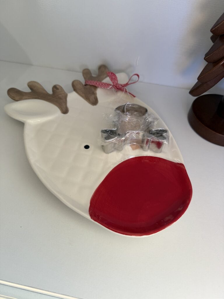 Festive reindeer holiday ornament with red nose, antlers, and ribbon decoration.