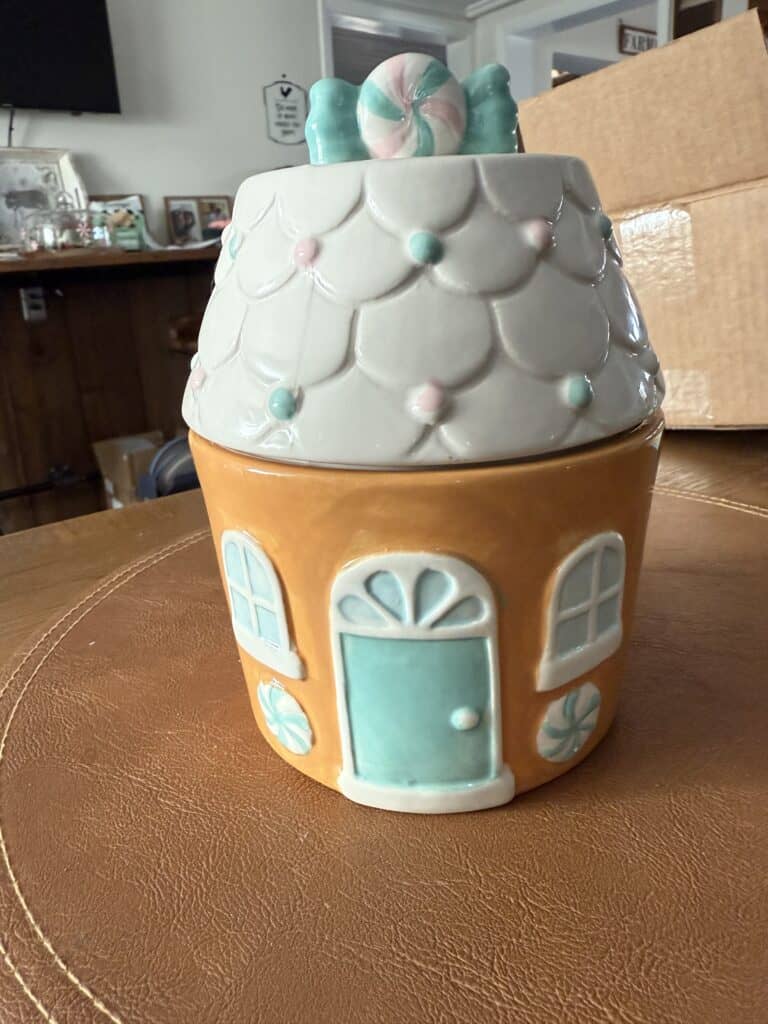 Colorful ceramic house-shaped jar with a candy on top, perfect for farmhouse decor or holiday treats.
