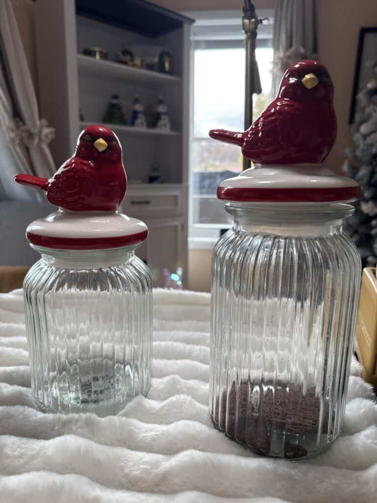 Colorful ceramic bird jar lids on glass storage jars.