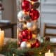 Colorful Christmas ornaments with pinecones in a glass vase for holiday home decor.