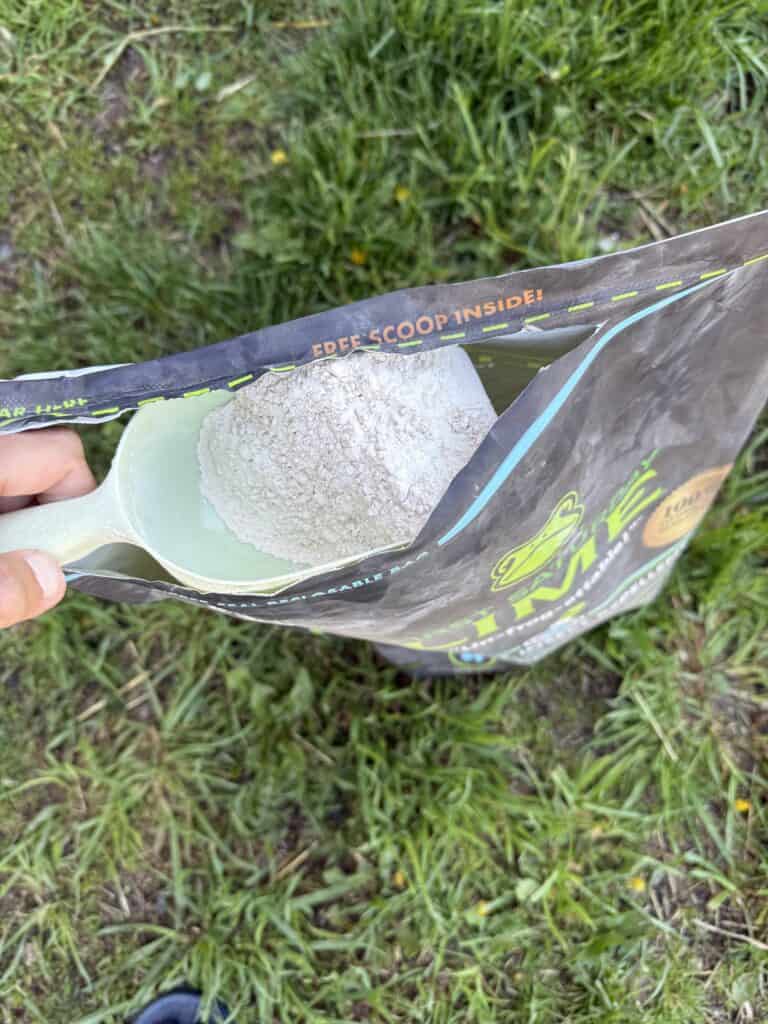 Why I Use First Saturday Lime All Over My Farm (And You Should Too) 2 Bag of gardening soil mix with stone, outdoors on grass.