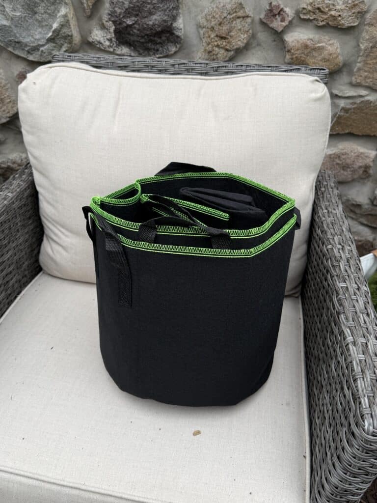 The Garden Journal: Week 1 - Tomato Planting Day 3 Durable black gardening tool bag with green accents, ideal for farming and gardening tools storage.