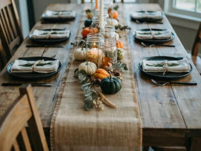 Rustic Thanksgiving table with pumpkins and candles for fall decor.