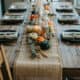 Rustic Thanksgiving table with pumpkins and candles for fall decor.