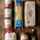 Basic grocery essentials including canned tomatoes, beans, pasta, rice, peanut butter, eggs, and oli.