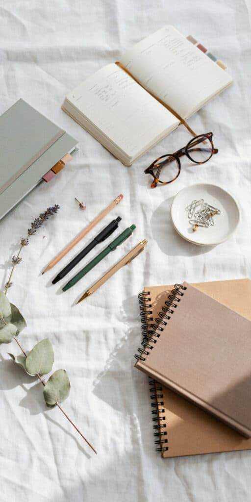 The Ultimate Back to School Survival Kit for Teens (A Complete School Bag Checklist) 2 Open notebook, pens, and glasses on a study desk for students.