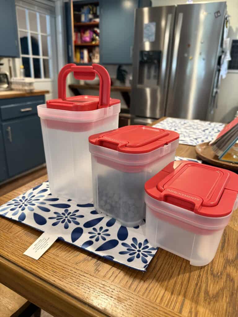 Pantry Organization Ideas That Actually Work in a Real Farmhouse Kitchen 2 Clear plastic food storage containers with red lids on a kitchen table.