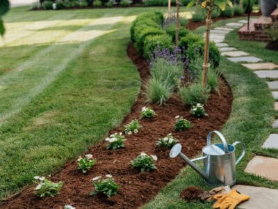 Beautiful front yard with flower bed, pathway, and lush lawn.