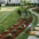 Beautiful front yard with flower bed, pathway, and lush lawn.