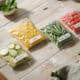 Prepped vegetables and corn in resealable bags for freezer meals.