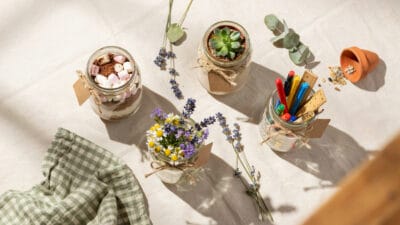 Creative mason jar teacher gifts with flowers and supplies.
