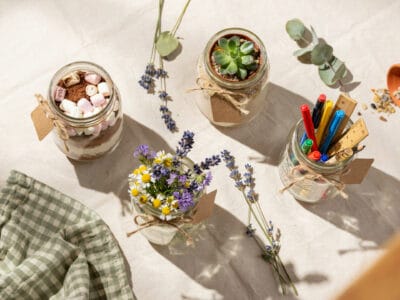 Creative mason jar teacher gifts with flowers and supplies.