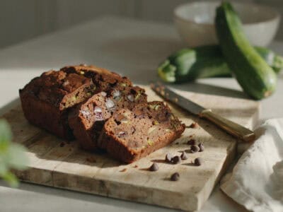 Close-up of a slice of chocolate zucchini bread on a wooden board.