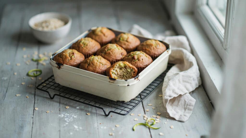 45 Zucchini Recipes to Use Up Every Last One From the Garden 4 Freshly baked zucchini muffins cooling on a wire rack by the window.