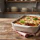 Delicious zucchini lasagna baked with cheese and fresh basil on a rustic wooden table.