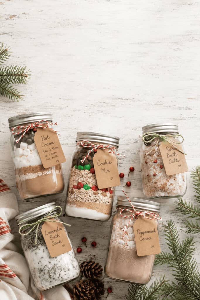 25 Mason Jar Christmas Gifts That Look Expensive (But Aren't) 1 Decorative mason jars with holiday-themed bath salts and scrubs for Christmas gifts.