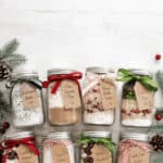8 Decorative mason jars with holiday-themed contents for Christmas gifts.