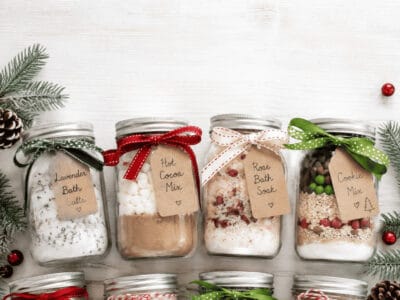 Decorative mason jars with holiday-themed contents for Christmas gifts.