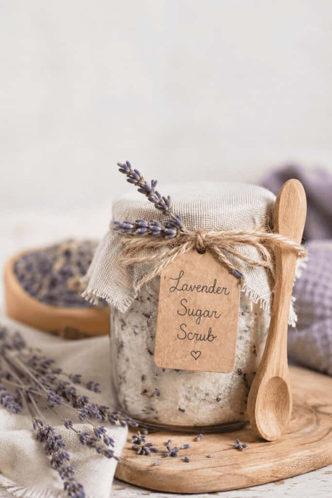 25 Mason Jar Christmas Gifts That Look Expensive (But Aren't) 5 Lavender sugar scrub in a mason jar with a wooden spoon and lavender sprig.