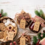 7 Assorted homemade Christmas food gifts with cookies, fudge, and nuts on a holiday table.
