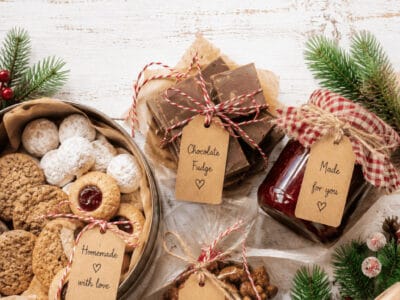 Assorted homemade Christmas food gifts with cookies, fudge, and nuts on a holiday table.