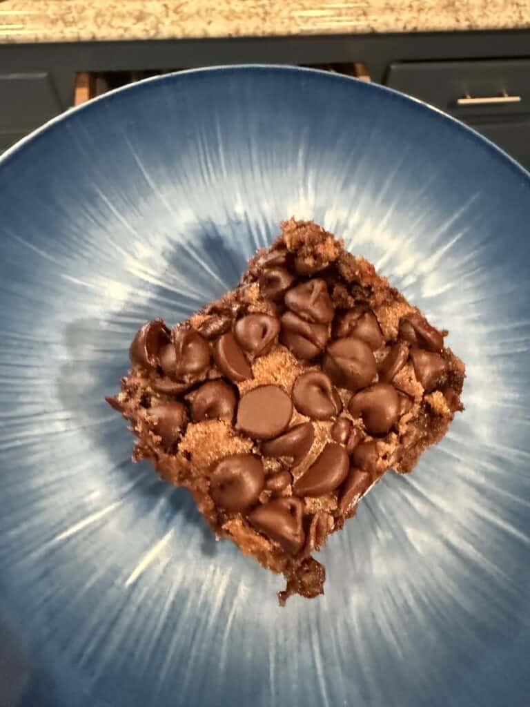 The Best Go To Chocolate Chip Zucchini Cake 13 Chocolate chip cookie bar on blue plate, close-up view.