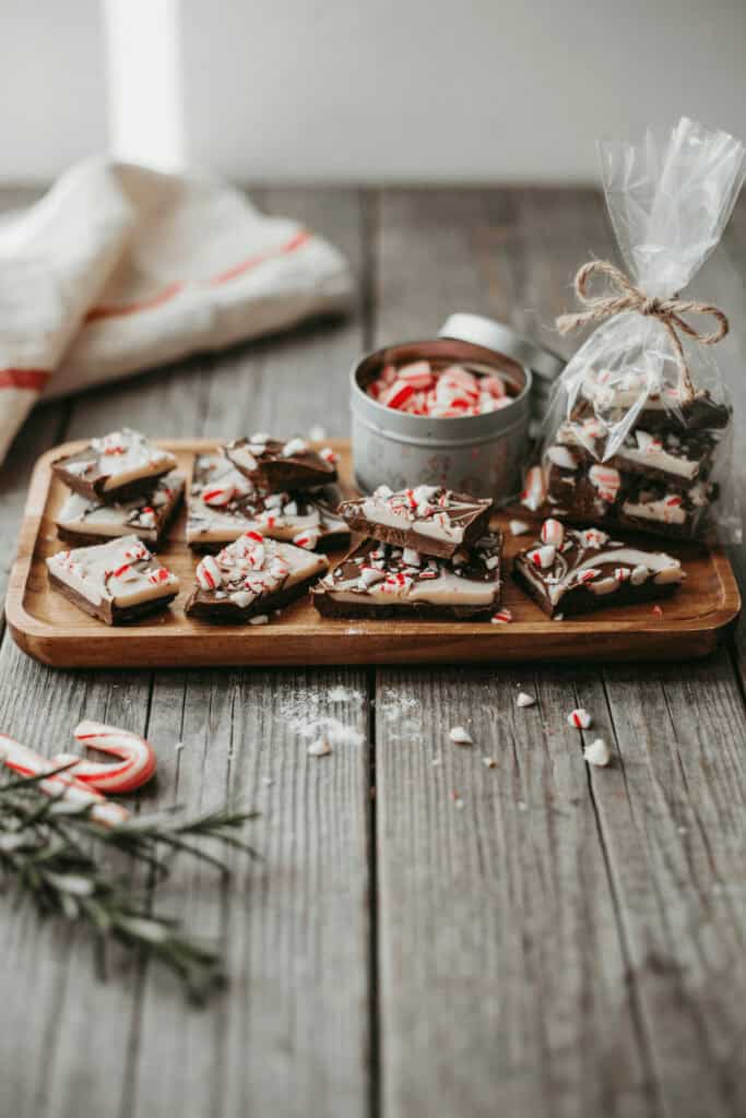 Homemade Food Gifts: 6 Easy Edible Christmas Gifts (With Recipes!) 3 Homemade peppermint bark on a wooden tray with festive decorations.