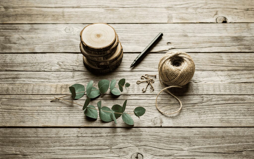 DIY Wood Slice Christmas Place Cards 2 Wood slices, twine, and greenery for DIY Christmas place cards.